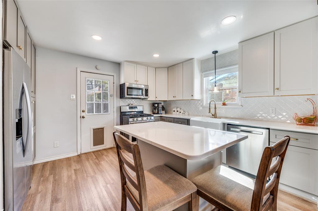 2924 West 11th Street Irving, TX 75060 - Photo 11 of 39 a kitchen with a dining table chairs refrigerator and cabinets
