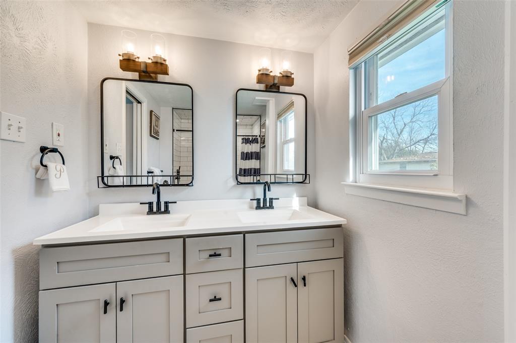 2924 West 11th Street Irving, TX 75060 - Photo 19 of 39 a bathroom with double vanity sinks and a mirror