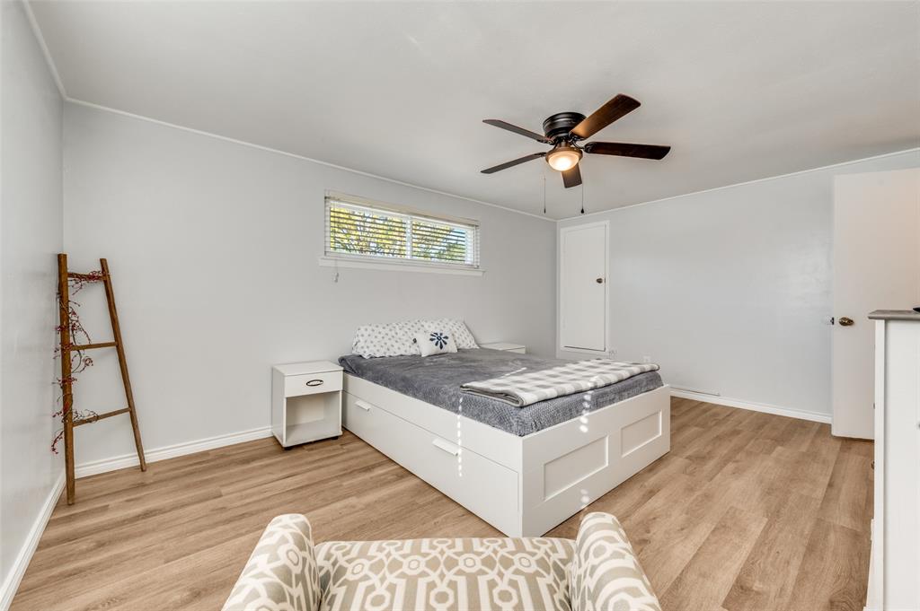 2924 West 11th Street Irving, TX 75060 - Photo 23 of 39 a living room with a bed furniture and a wooden floor