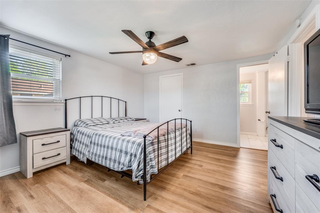 2924 West 11th Street Irving, TX 75060 - Photo 30 of 39 a bedroom with a bed and a chandelier
