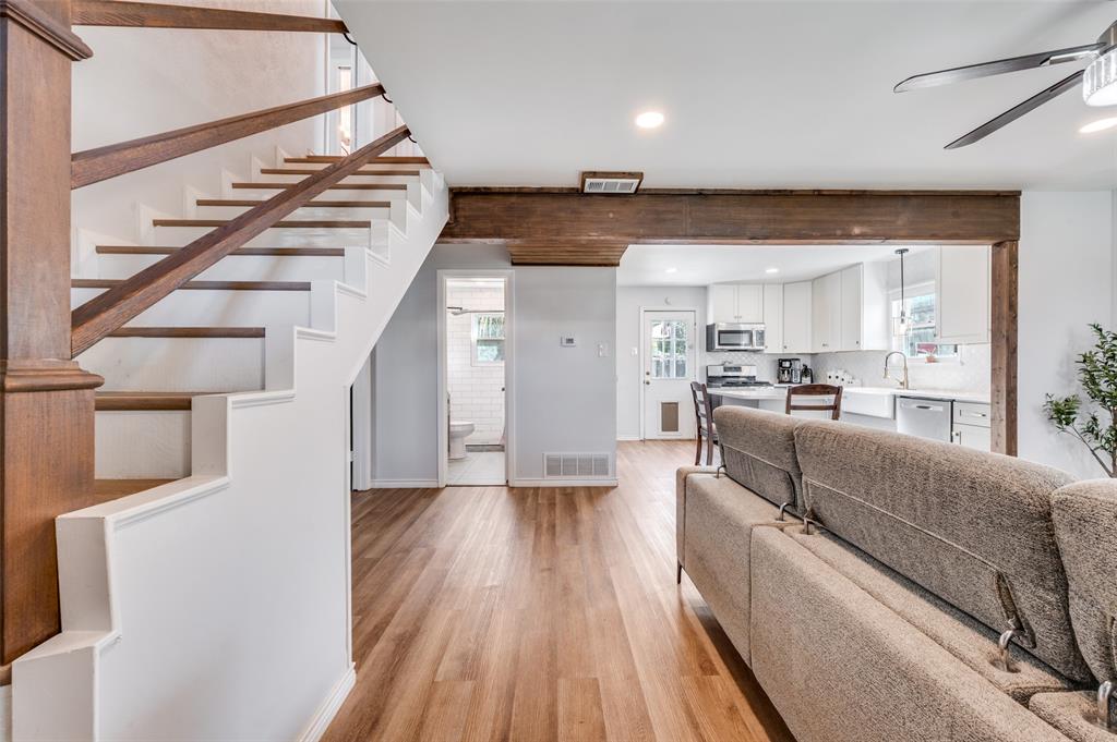 2924 West 11th Street Irving, TX 75060 - Photo 5 of 39 a living room with couches and kitchen view with wooden floor