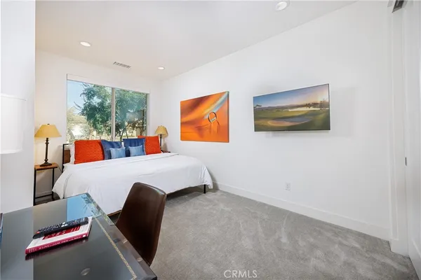 a bed room with a bed and a painting on the wall