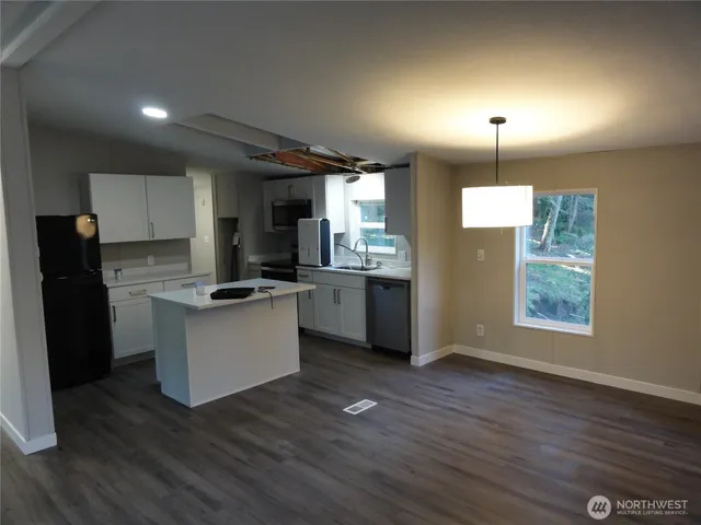a kitchen with stainless steel appliances a refrigerator and wooden floor