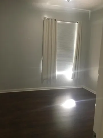 view of empty room with wooden floor and fan