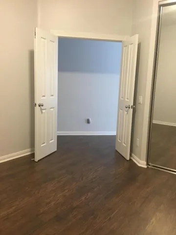 an empty room with wooden floor and white doors