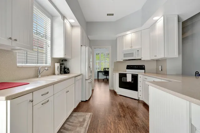 a kitchen with granite countertop a sink stainless steel appliances and cabinets