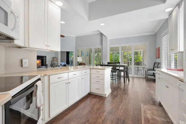 a kitchen with white cabinets and chairs
