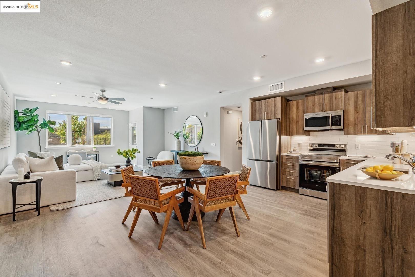 2400 Adeline Street, Unit 101 Oakland, CA 94607 - Photo 2 of 17 a view of a dining room with furniture a kitchen and chandelier