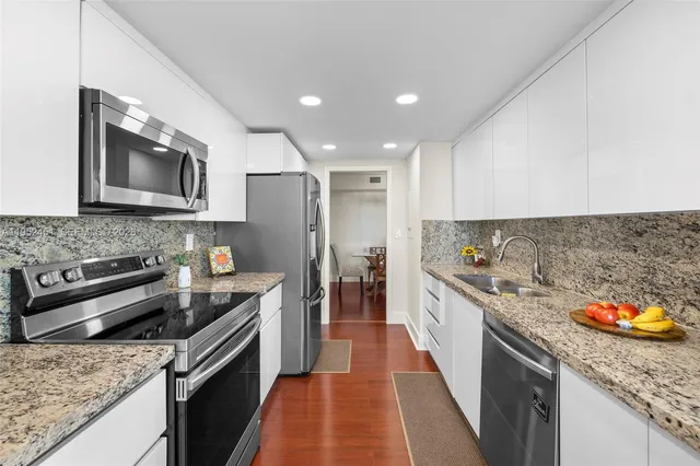 a kitchen with stainless steel appliances granite countertop a sink stove and refrigerator