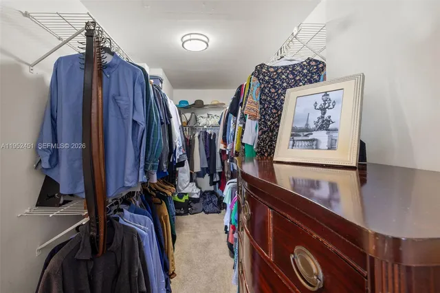 a view of walk in closet with clothes