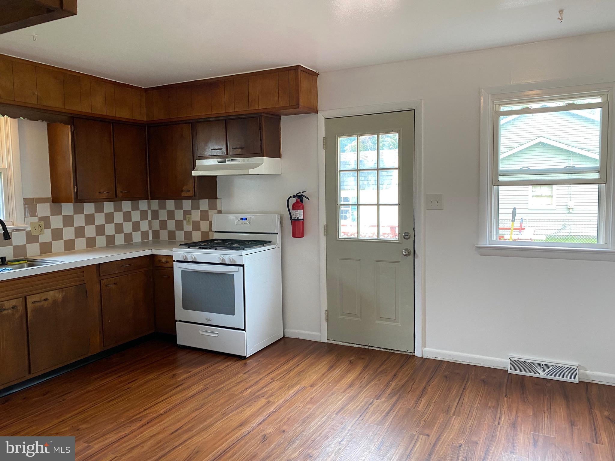 4 Riviera Drive Pennsville, NJ 08070 - Photo 5 of 22 a kitchen with granite countertop wooden floors and white stainless steel appliances
