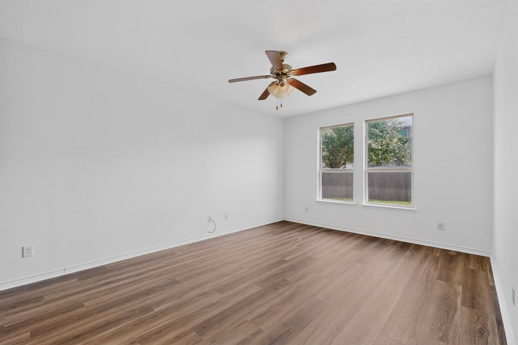 426 Harding Lane Lavon, TX 75166 - Photo 17 of 40 Bright room with wood-finish flooring, white walls, and a ceiling fan with integrated lighting