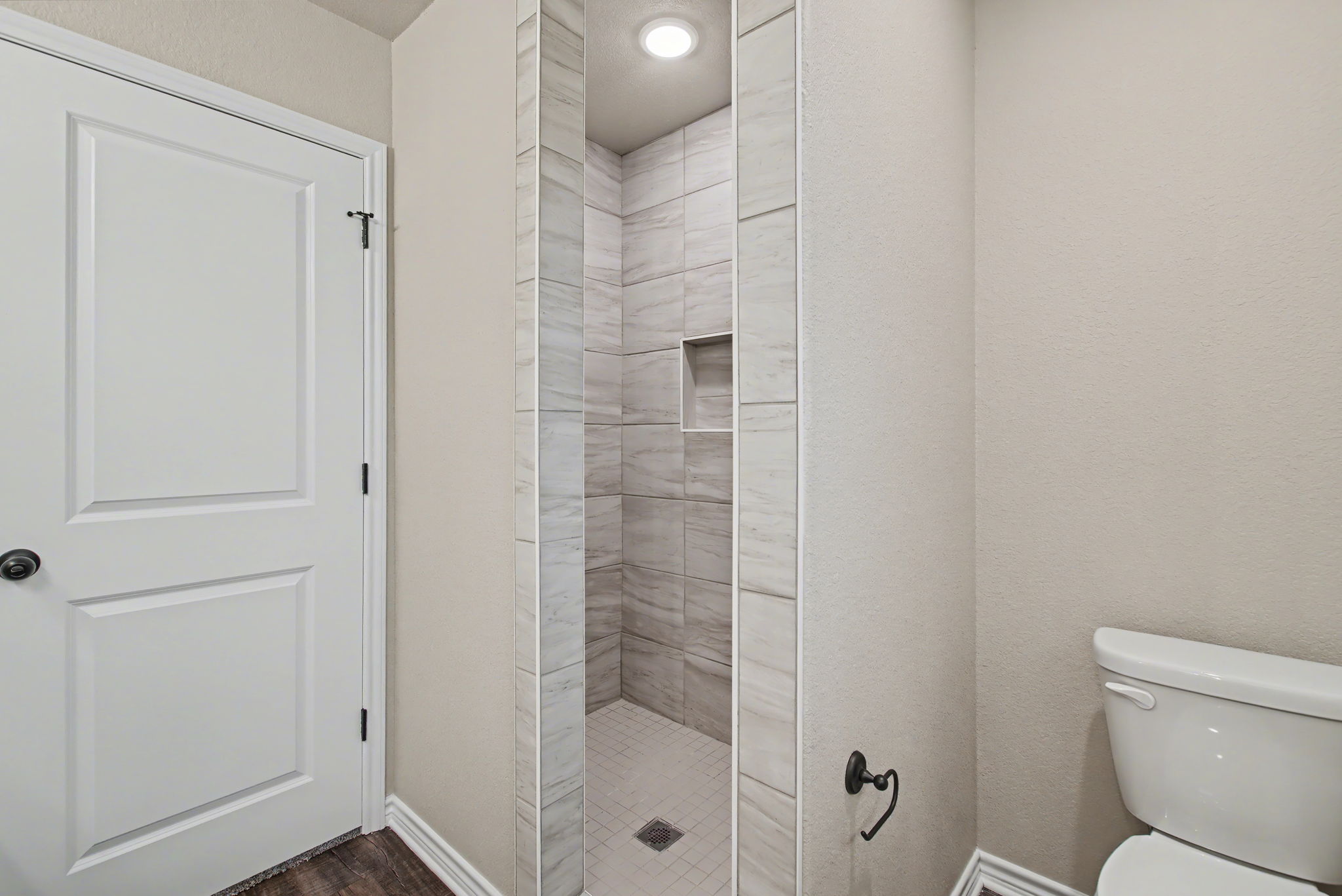 206 Water Wl Road Burnet, TX 78611 - Photo 14 of 25 Clean lines and custom tile work define this modern bathroom with a walk-in shower.