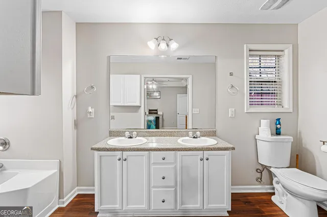 a bathroom with a sink a toilet a large mirror and shower