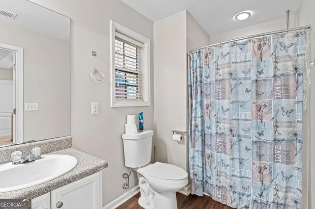 a bathroom with a granite countertop sink toilet and shower