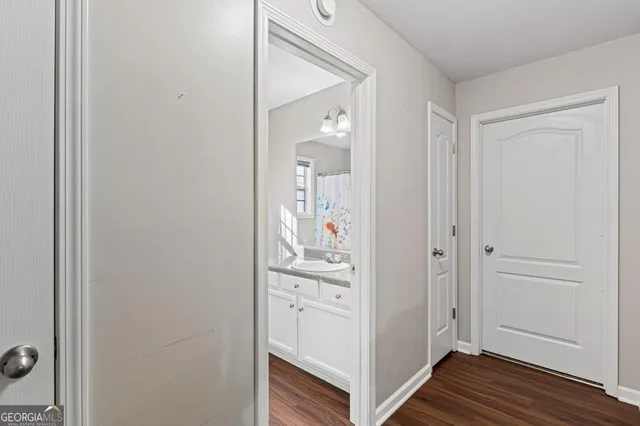 a view of a hallway with wooden floor and closet