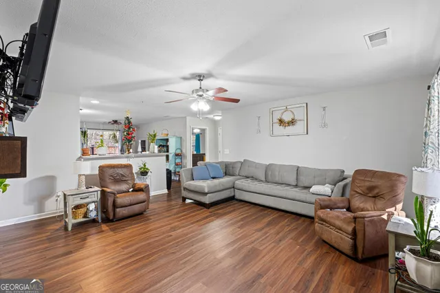 a living room with furniture and a wooden floor