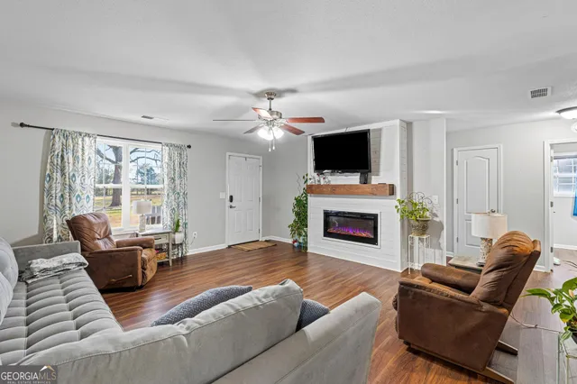 a living room with furniture a fireplace and a flat screen tv