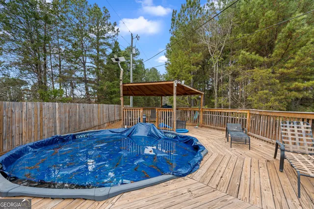 a view of a wooden deck with a bench and trees