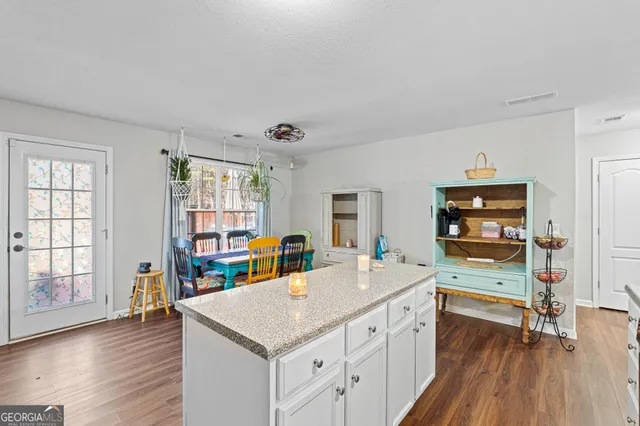 a kitchen with a sink stove and wooden floor