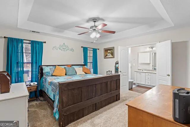 a bedroom with a large bed and a chandelier