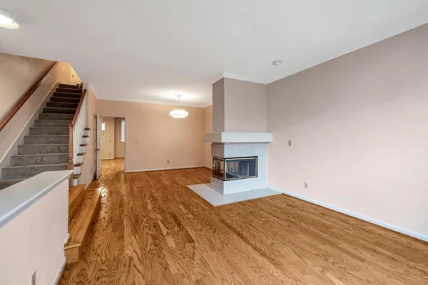 a view of a livingroom with wooden floor and staircase
