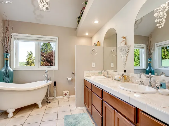 a spacious bathroom with a double vanity sink a mirror and a bathtub