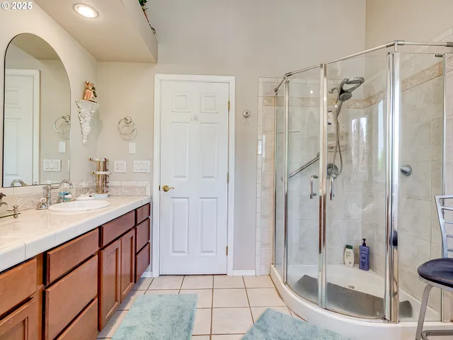 a spacious bathroom with a shower sink and mirror