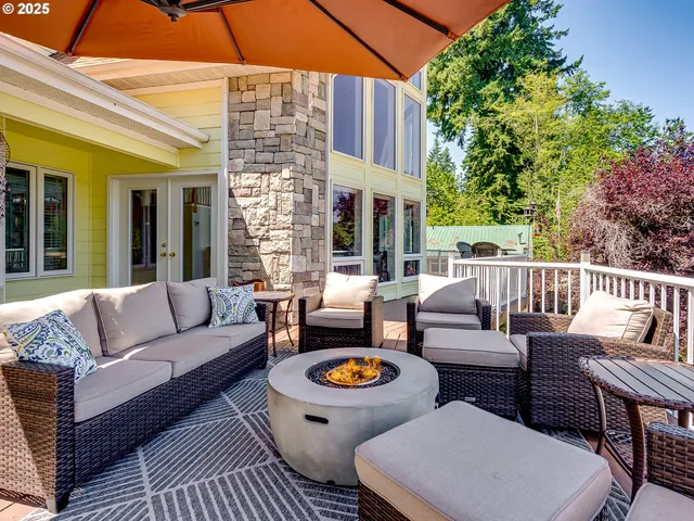 a view of a patio with couches table and chairs under an umbrella