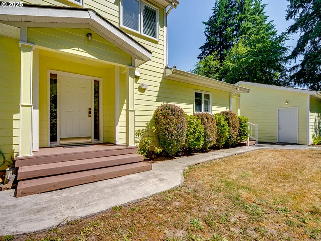 a view of house with backyard and glass windows