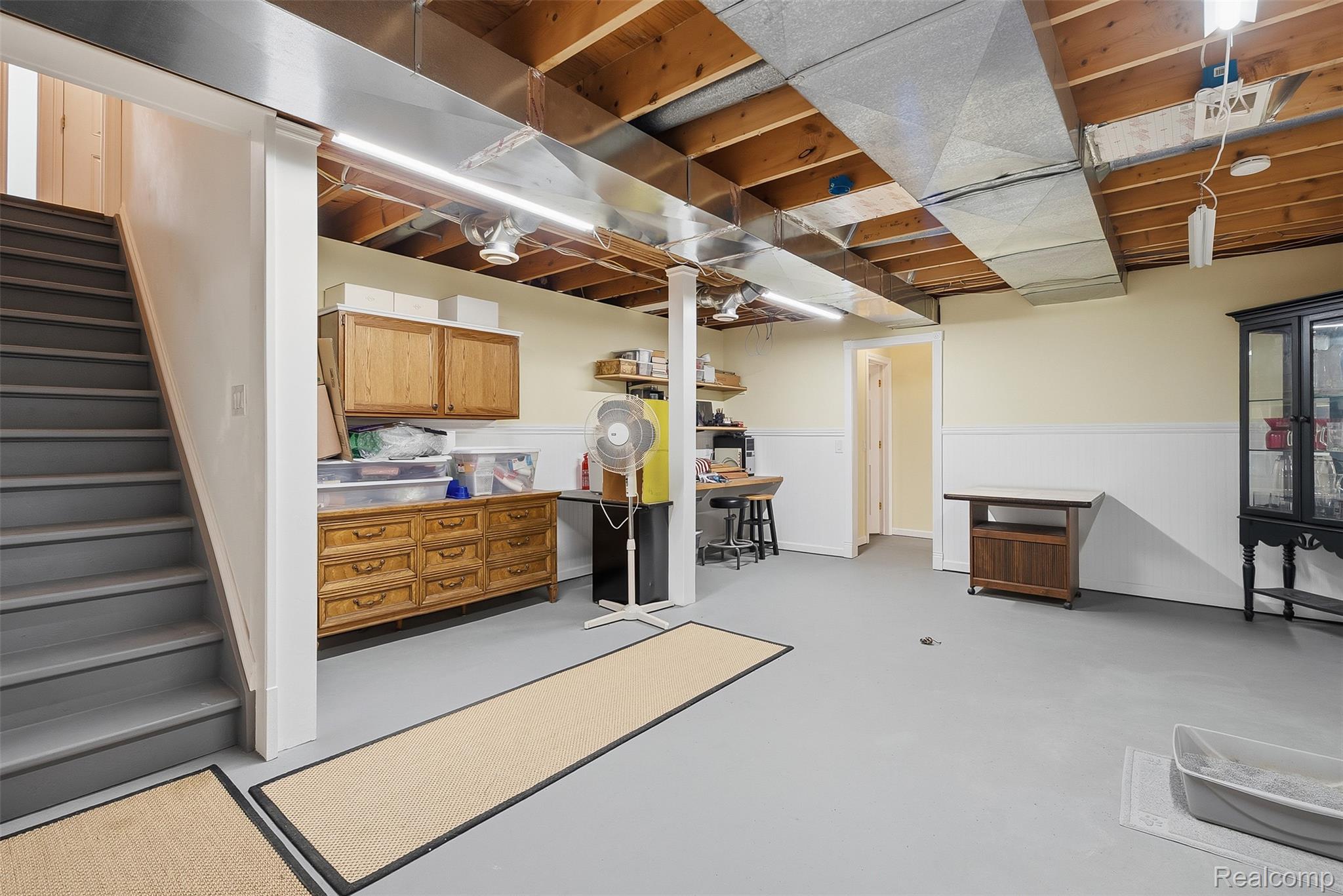 13182 Gilbert Road Memphis, MI 48041 - Photo 27 of 48 Expansive lower-level space featuring a painted concrete floor, white wainscoting, and exposed ceiling joists