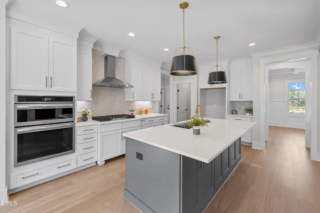 a kitchen with stainless steel appliances kitchen island granite countertop a stove a sink a center island and cabinets