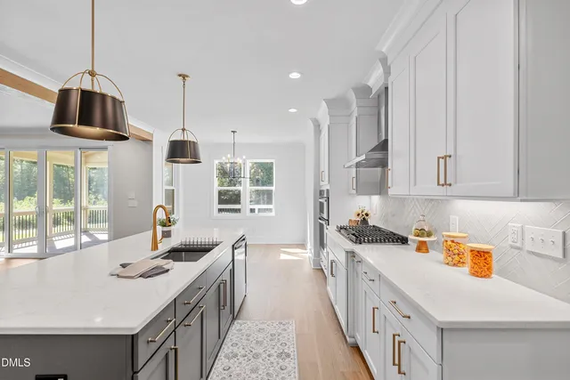 a kitchen that has a sink a stove and a wooden floors