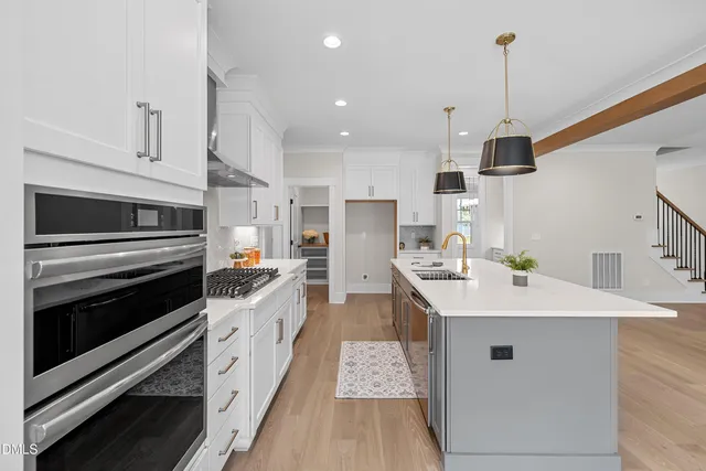 a kitchen with stainless steel appliances kitchen island granite countertop a sink and a stove