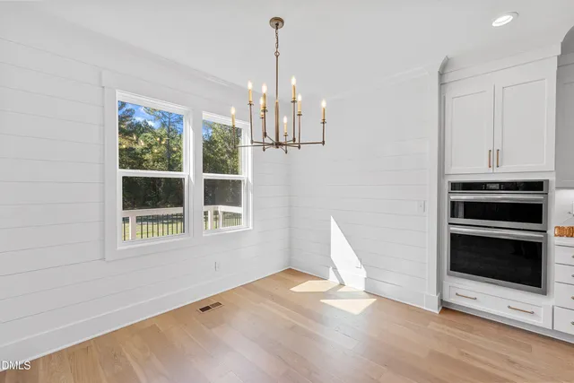 a view of empty room with wooden floor and window
