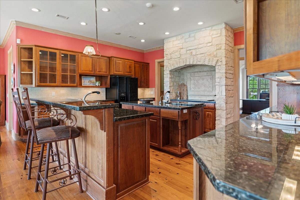 167 Wimberley Ranch Drive Wimberley, TX 78676 - Photo 9 of 40 a kitchen with stainless steel appliances granite countertop a stove a sink and a microwave