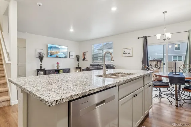 a kitchen with granite countertop kitchen island a sink and a refrigerator