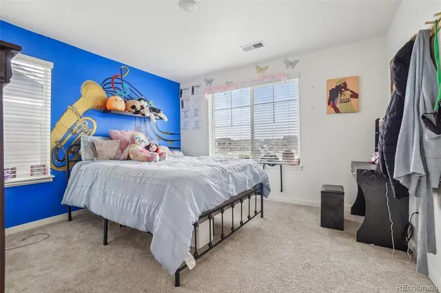 a bed sitting in a bedroom next to a window