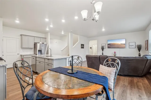a kitchen with stainless steel appliances granite countertop a sink a table and chairs