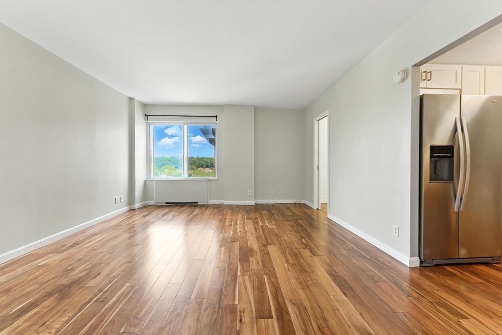 22 Chestnut Place, Unit 608 Brookline, MA 02445 - Photo 14 of 29 an empty room with wooden floor cabinet and windows