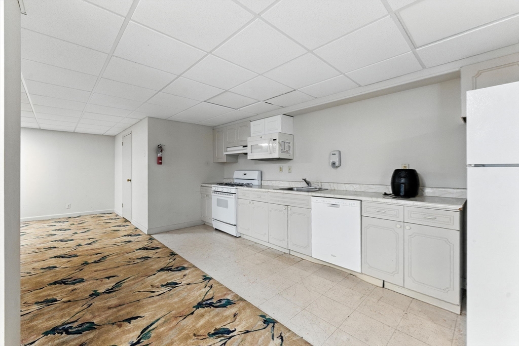 22 Chestnut Place, Unit 608 Brookline, MA 02445 - Photo 25 of 29 a large white kitchen with cabinets appliances and a counter space