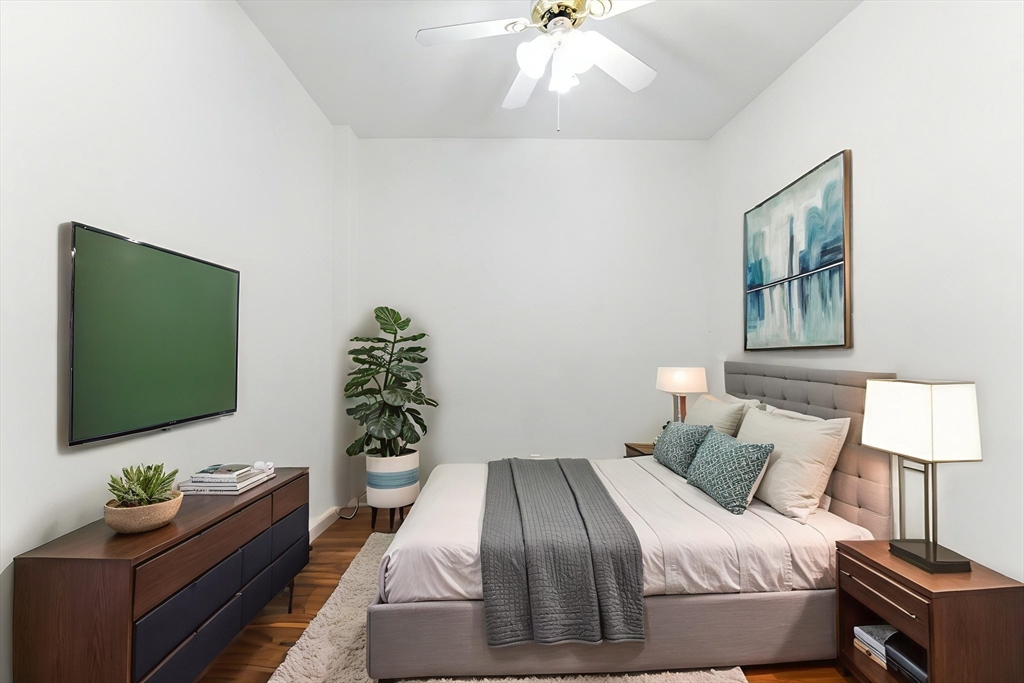 22 Chestnut Place, Unit 608 Brookline, MA 02445 - Photo 3 of 29 a bedroom with a bed and a flat screen tv