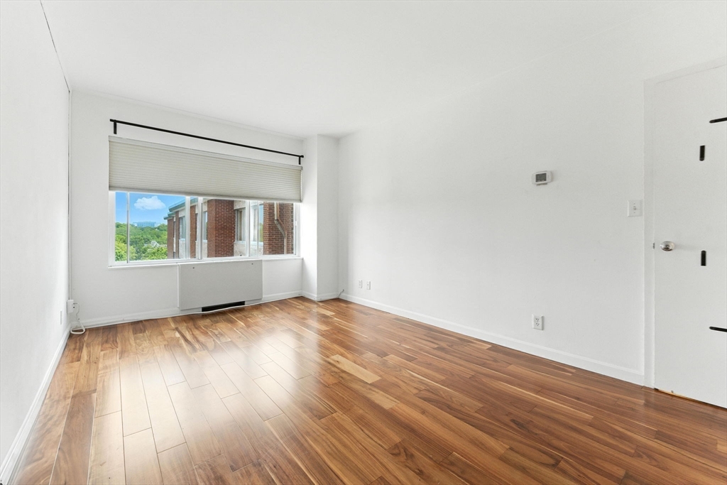 22 Chestnut Place, Unit 608 Brookline, MA 02445 - Photo 8 of 29 a view of an empty room with wooden floor and a window