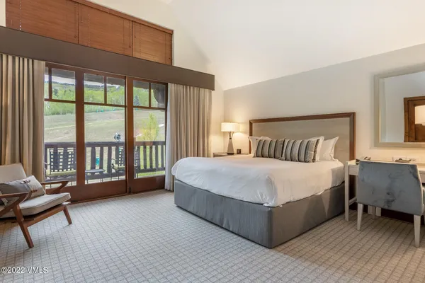 a bedroom with a bed and a large window