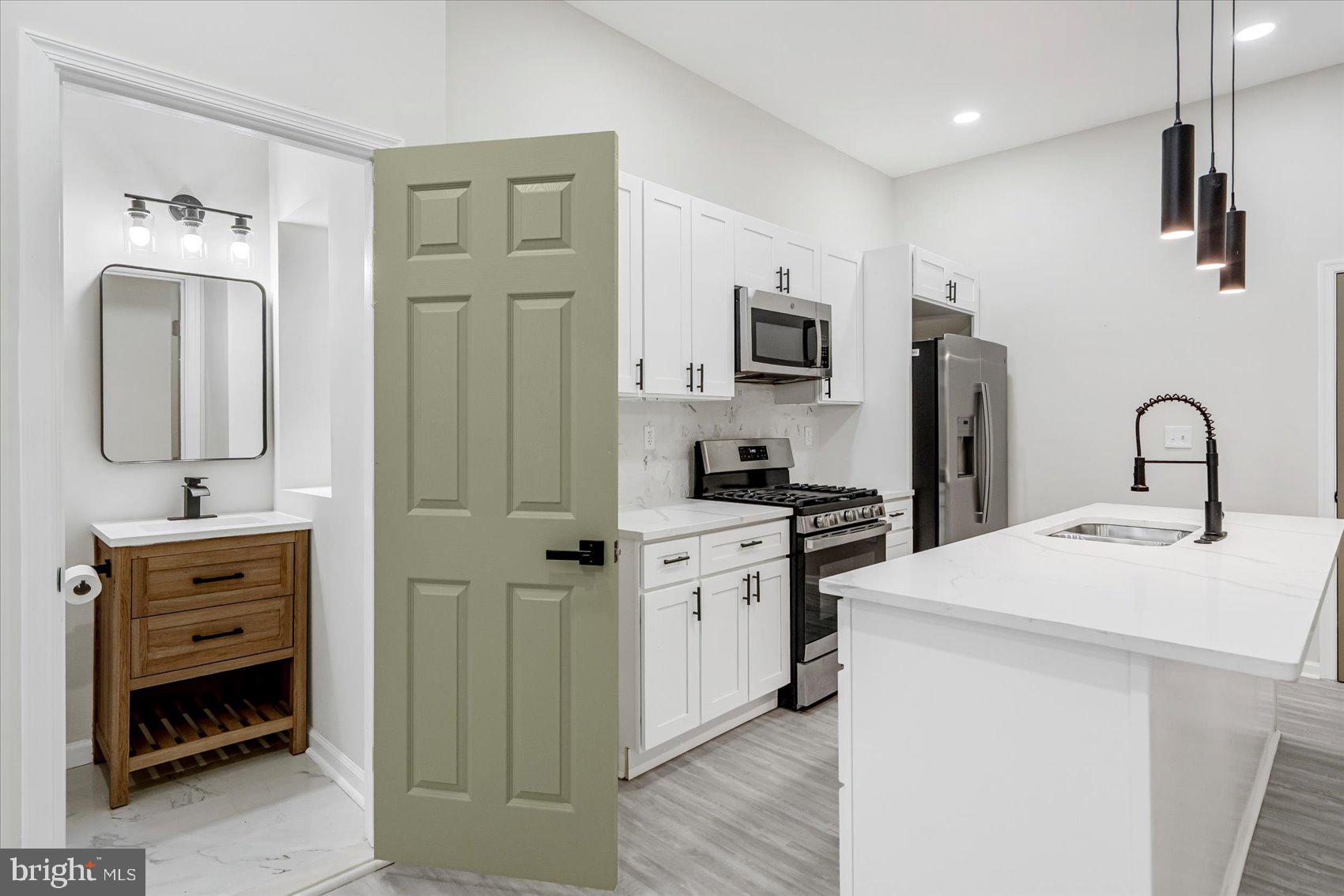 1743 Federal Street Baltimore, MD 21213 - Photo 9 of 47 a kitchen with stainless steel appliances a stove microwave and refrigerator