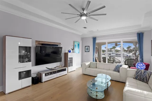 a living room with furniture kitchen view and a chandelier