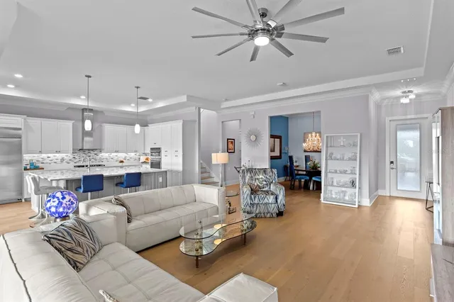 a kitchen with stainless steel appliances kitchen island granite countertop a table chairs and a wooden cabinets