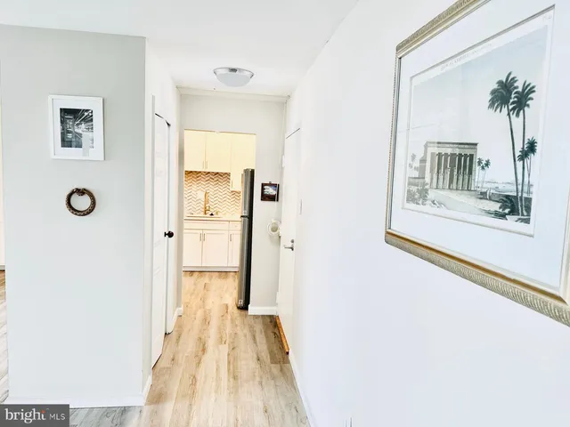 a view of a hallway with wooden floor and a living room