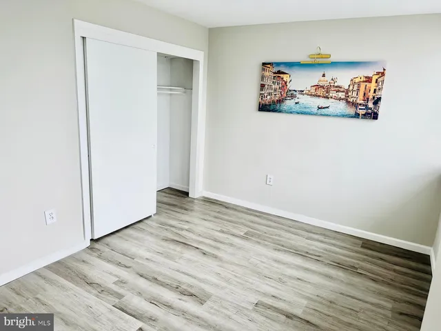 an empty room with wooden floor and window