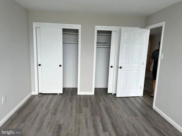 an empty room with wooden floor and a sink